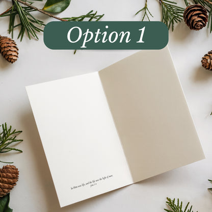 Open book with a Christmas-themed cover featuring greenery and pinecones on a white background.