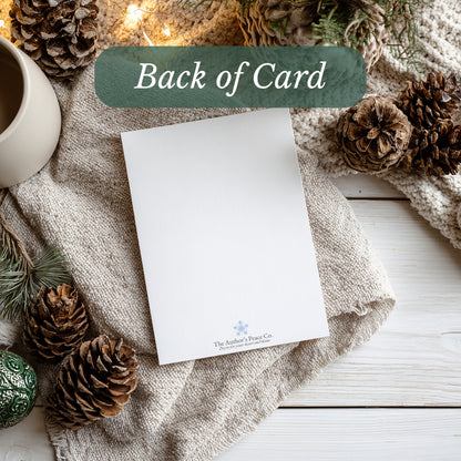 White card with a brand logo on a textured surface with pinecones and a mug.