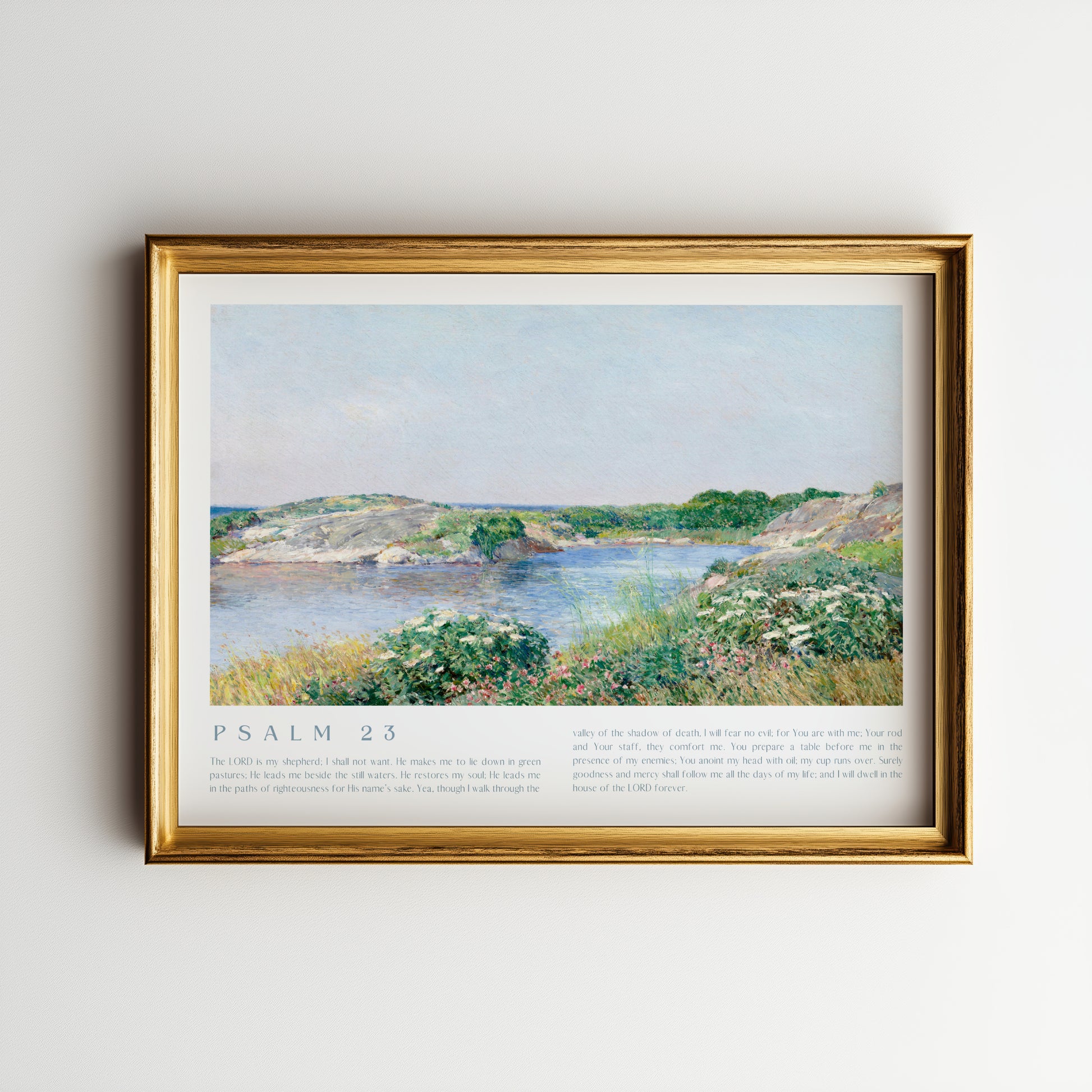 Framed artwork of a landscape with a body of water and greenery on a light gray wall.