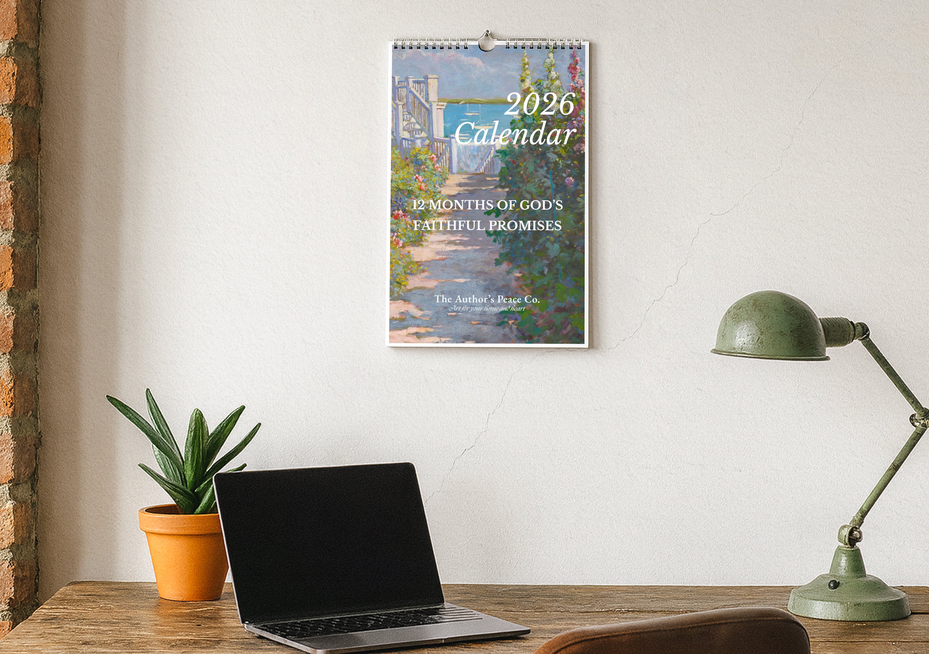 2026 calendar on a wall above a desk with a laptop and lamp.