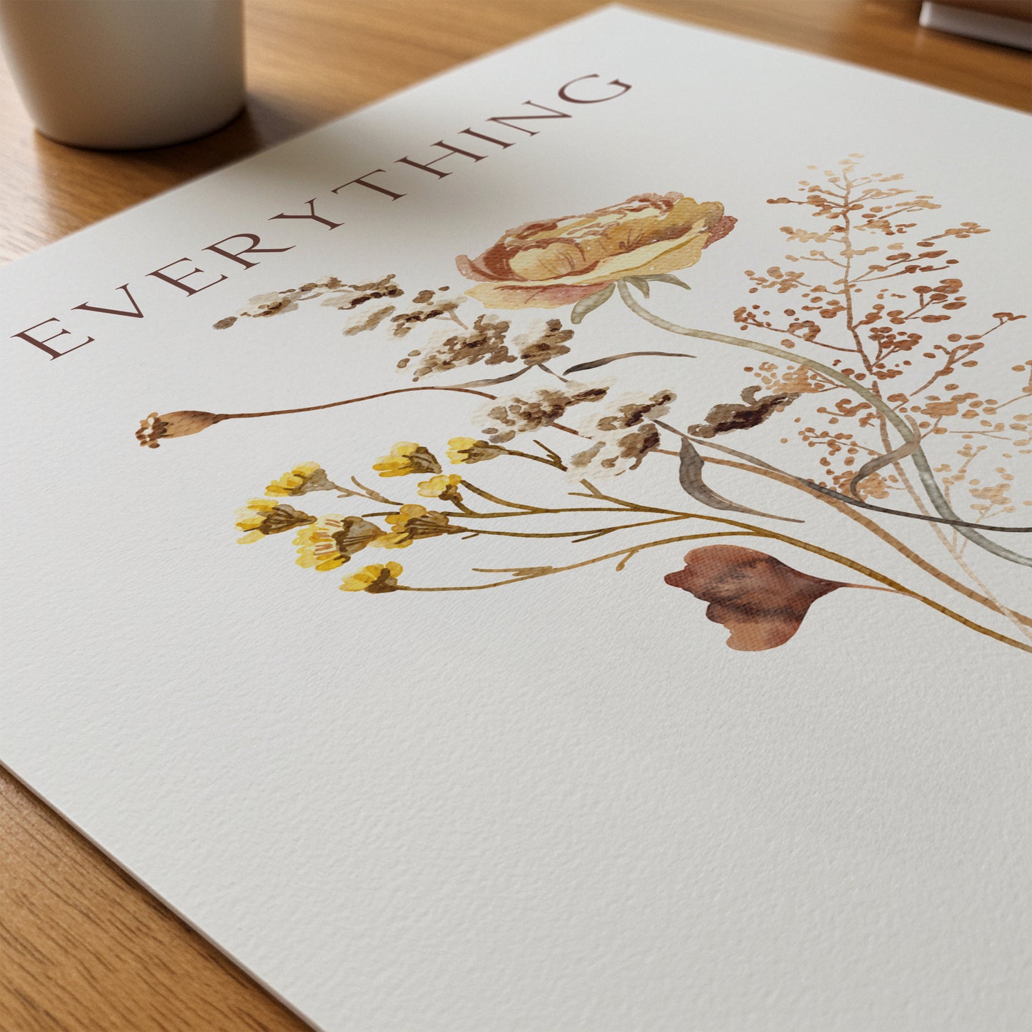 art print with floral design and 'Everything' text on a wooden surface