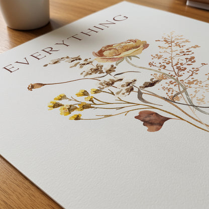 art print with floral design and 'Everything' text on a wooden surface