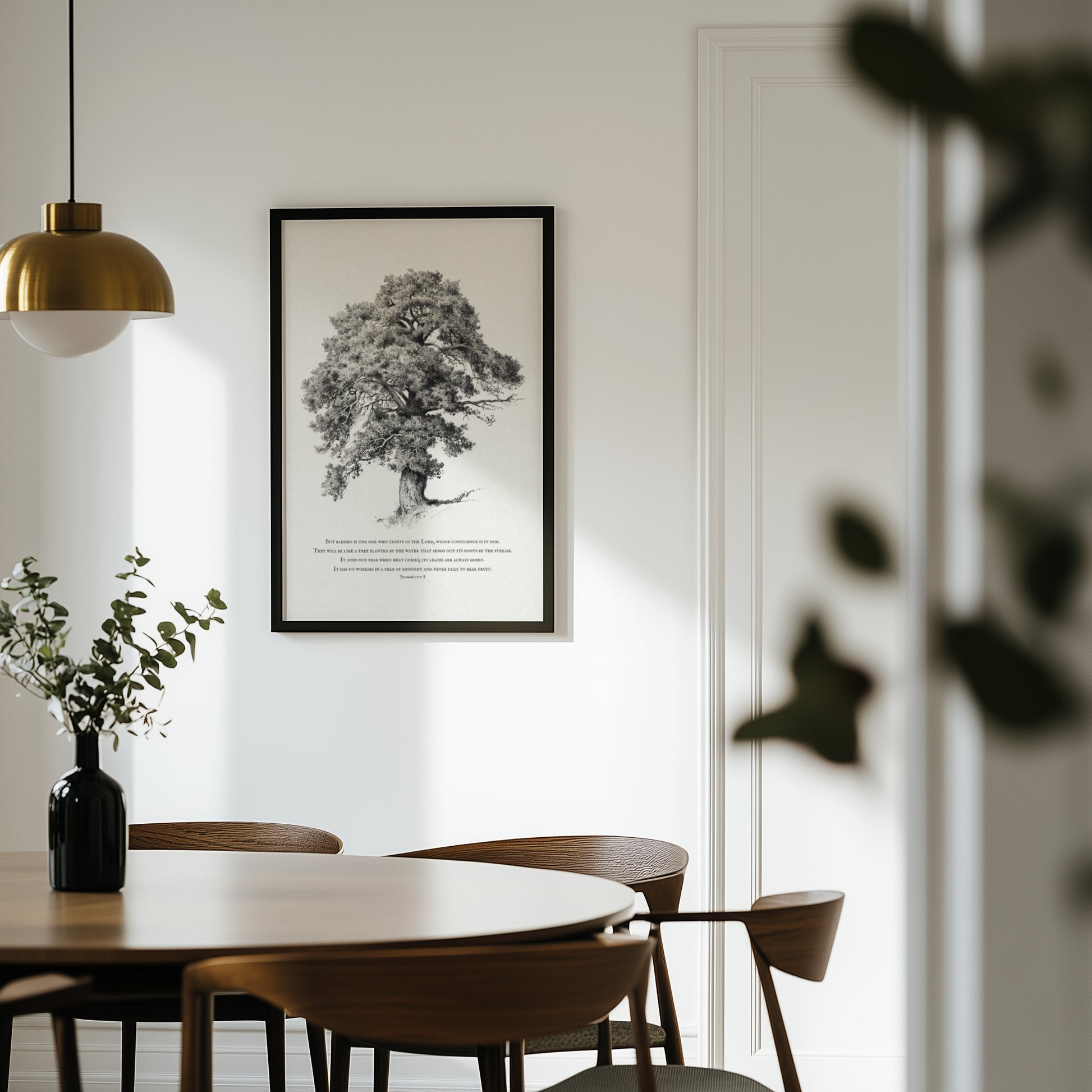 Dining room with wooden table and chairs, framed black and white tree print on the wall.