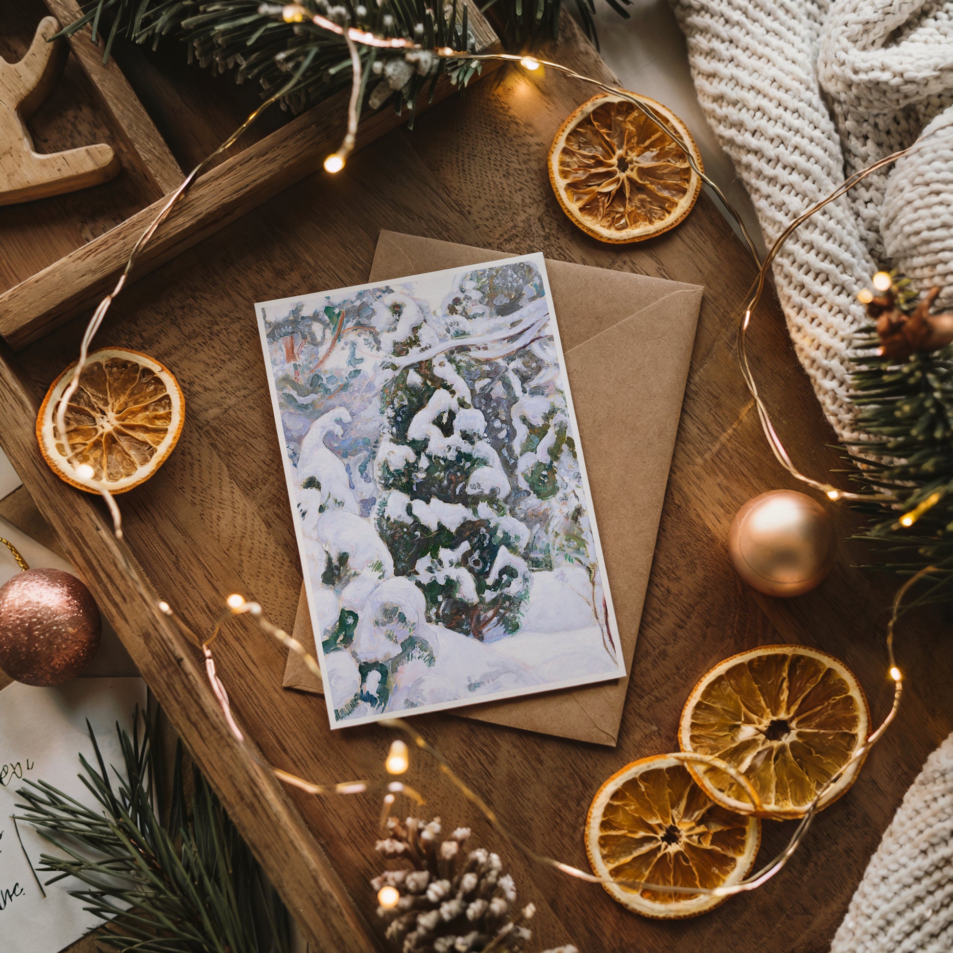 Christmas card with envelope on a wooden surface with decorative elements