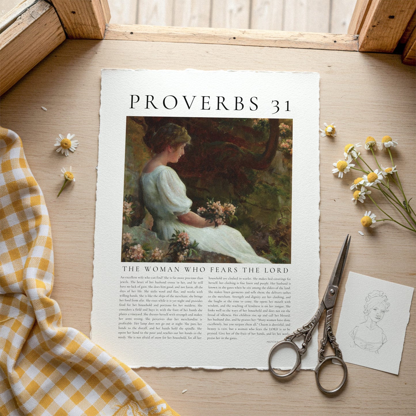 Sheet of paper with 'Proverbs 31' text and illustration on a wooden surface with flowers and scissors.