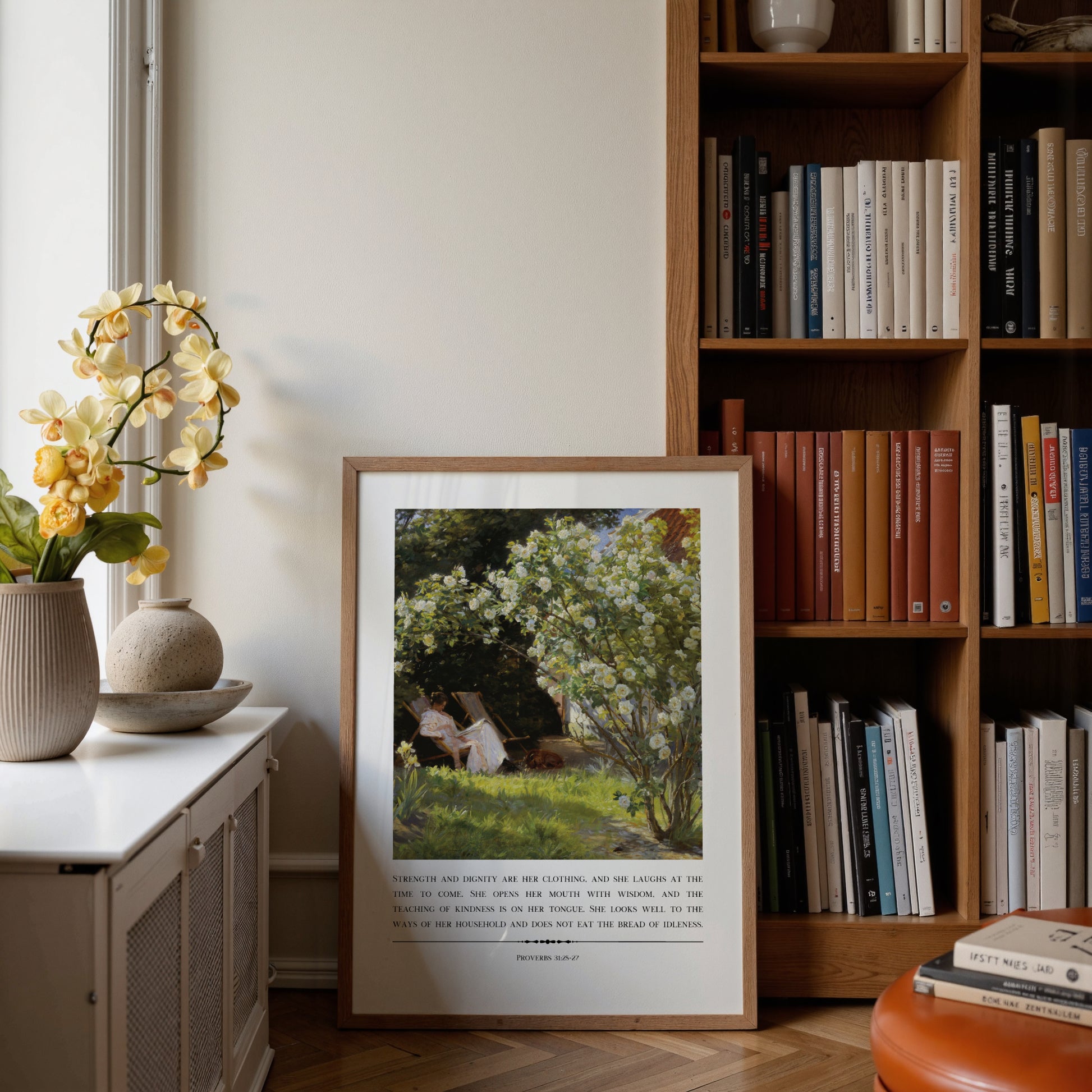 Framed artwork on a side table next to a bookshelf with books and decor.