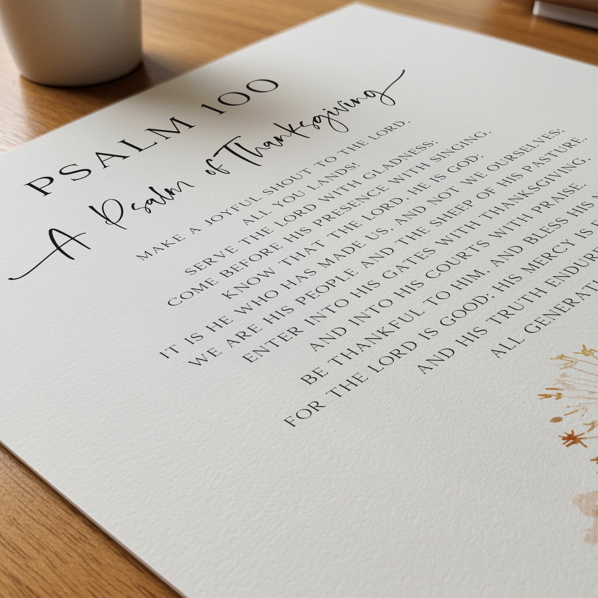 Sheet of paper with printed text titled 'Psalm 100 A Psalm of Thanksgiving' on a wooden surface.