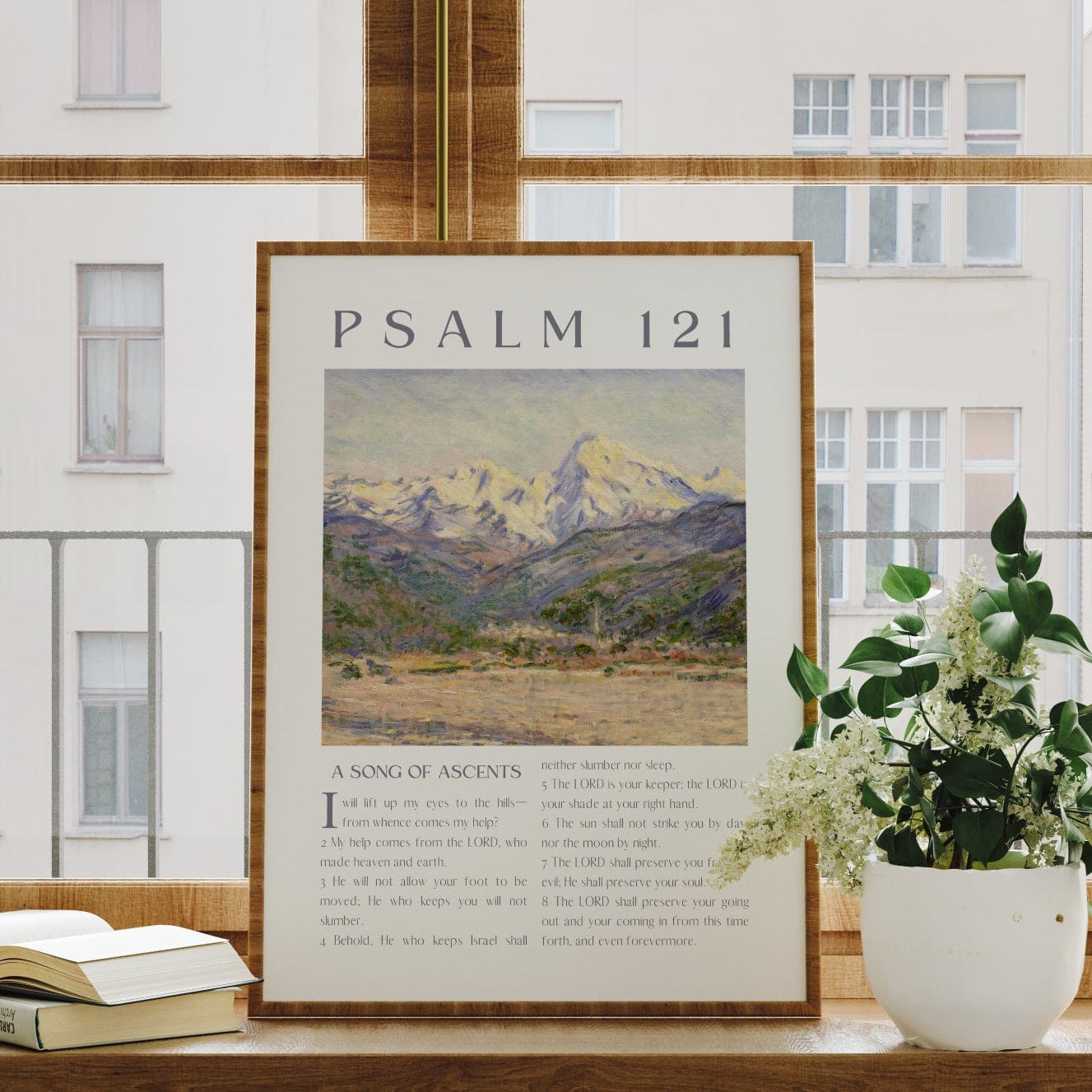 Framed poster titled 'Psalm 121' on a window sill with a plant and books.