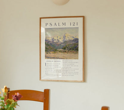 Framed artwork with 'Psalm 121' on a wall above a wooden chair with flowers.