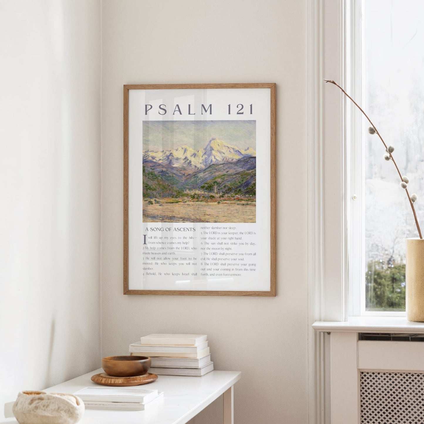 Framed artwork with mountain landscape and 'Psalm 121' text on a wall in a home setting.