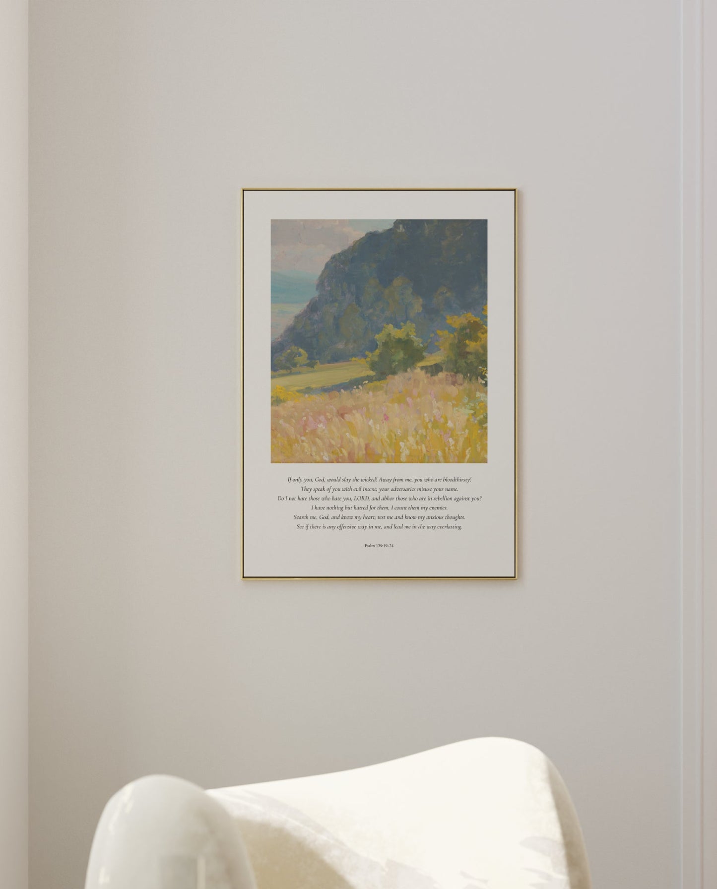 Framed landscape print on a wall above a white chair
