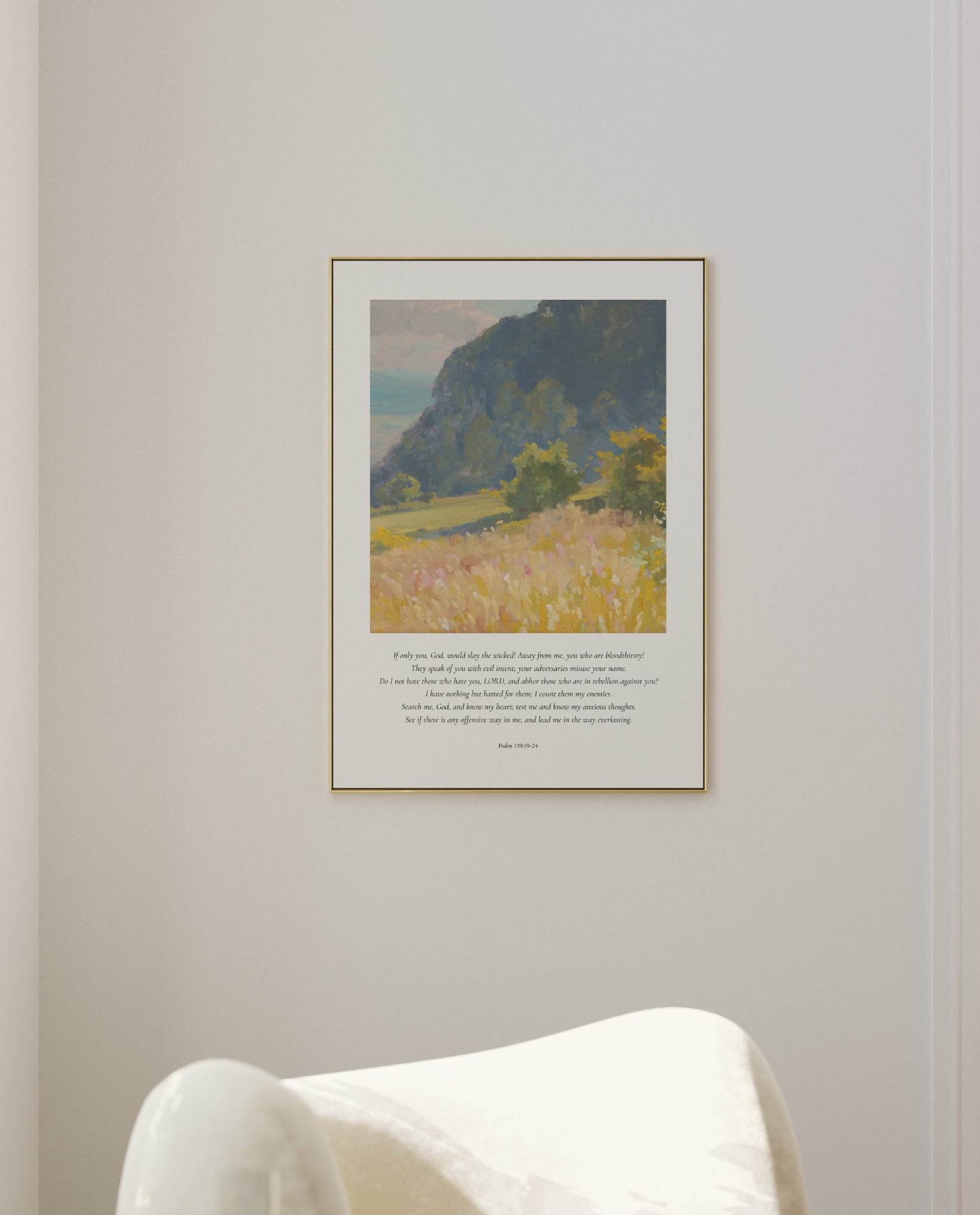 Framed landscape print on a wall above a white chair