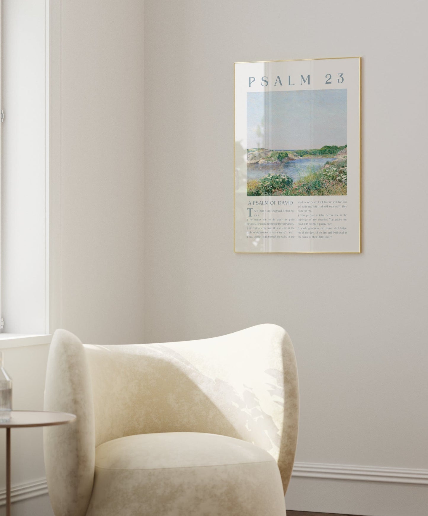 Modern living room with a white armchair, side table, and framed artwork on the wall.