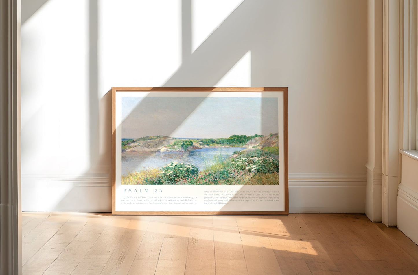 Framed landscape painting on a wall in a bright room with sunlight streaming through windows.