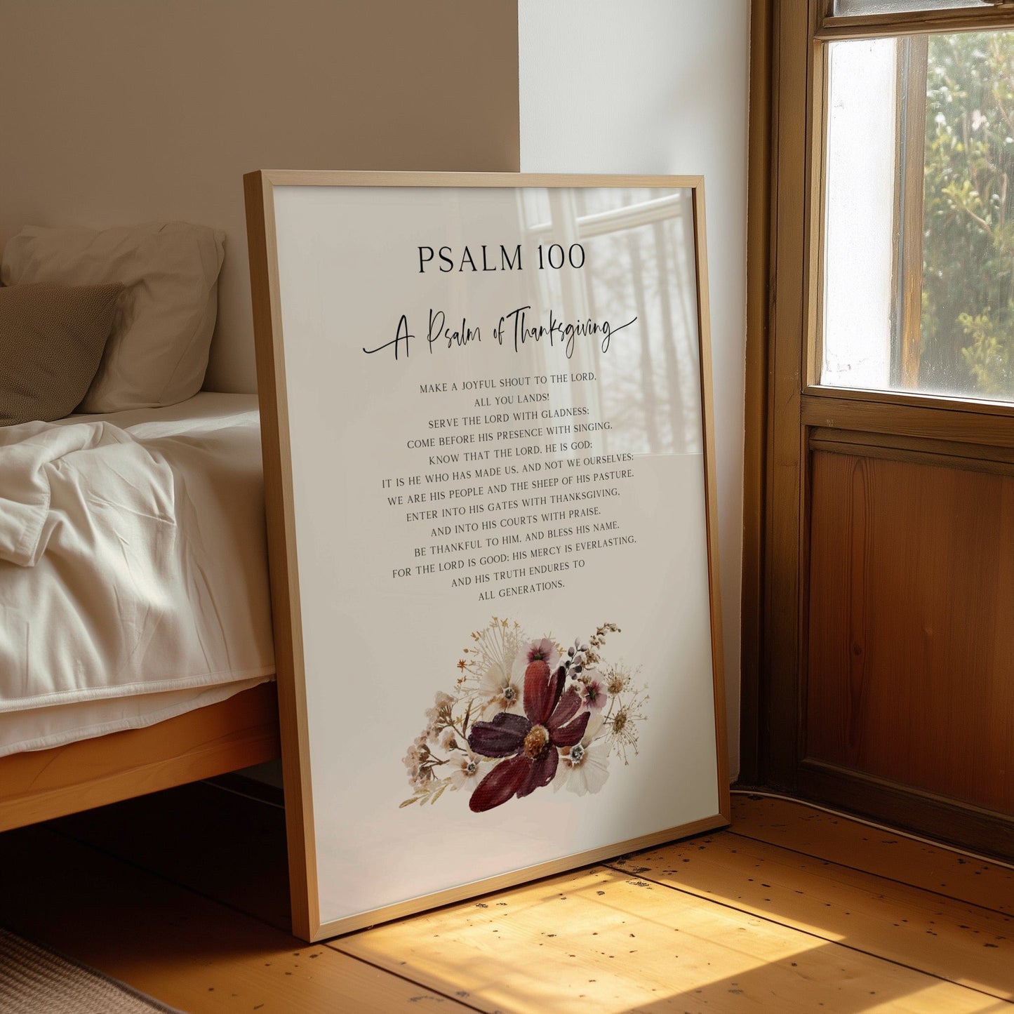 Framed poster with 'Psalm 100' text in a room with a bed and window.