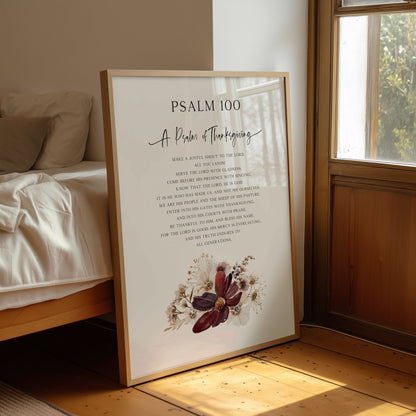 Framed poster with 'Psalm 100' text in a room with a bed and window.