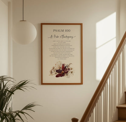 Framed artwork of Psalm 100 on a wall above a staircase with a plant to the left.