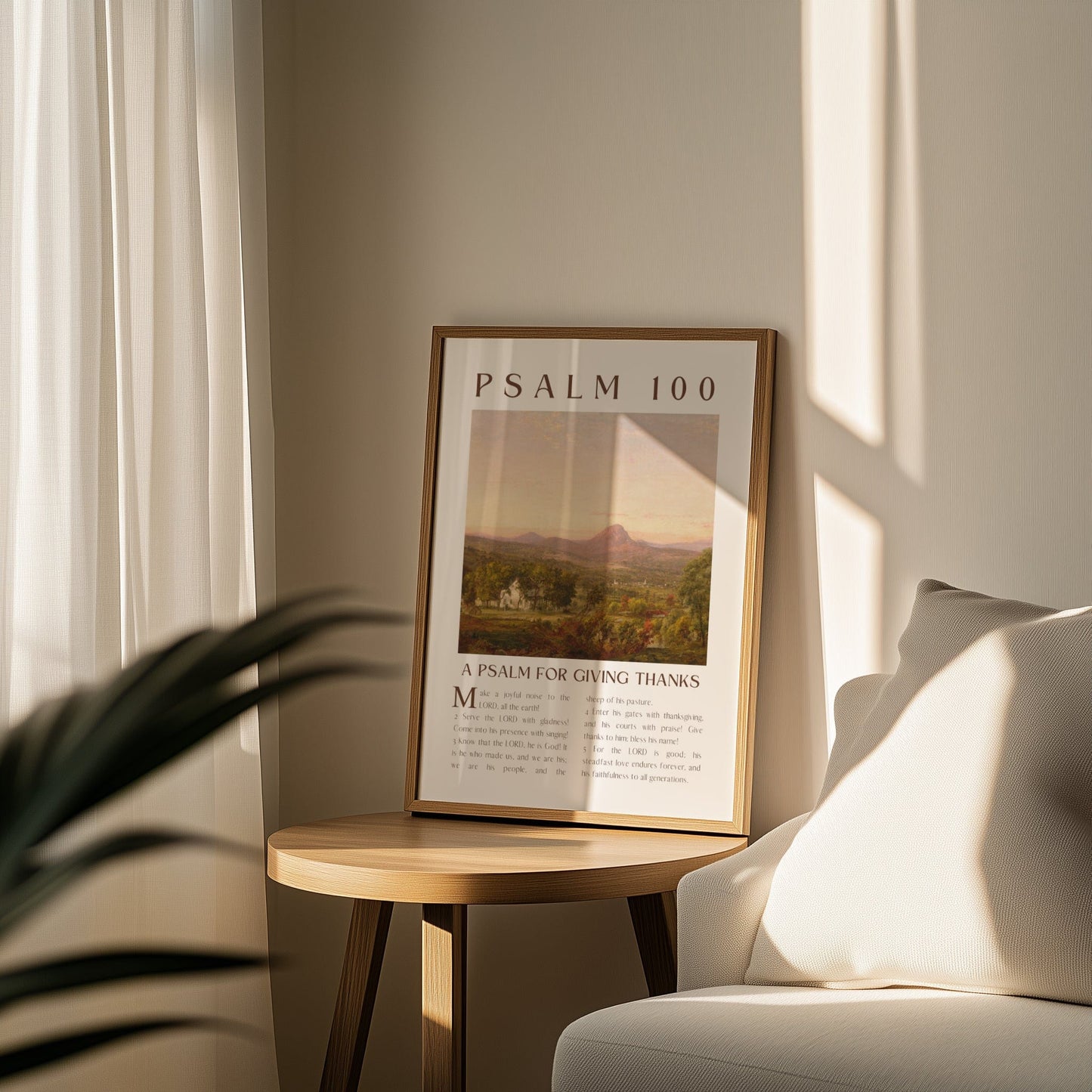 Framed poster of Psalm 100 on a wooden side table with a couch and plant in the background