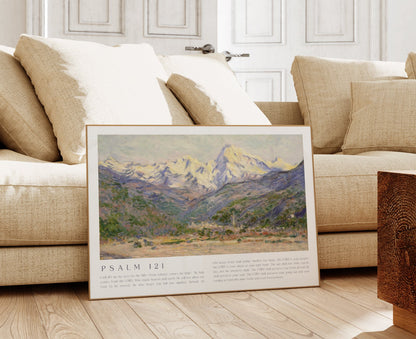 Framed landscape print on a wooden floor in a living room with a beige sofa.