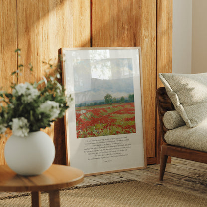 Framed artwork of a landscape with flowers and a chair in a room with wooden walls.