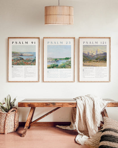 Three framed prints titled 'Psalm 91', 'Psalm 23', and 'Psalm 121' above a wooden bench in a room.