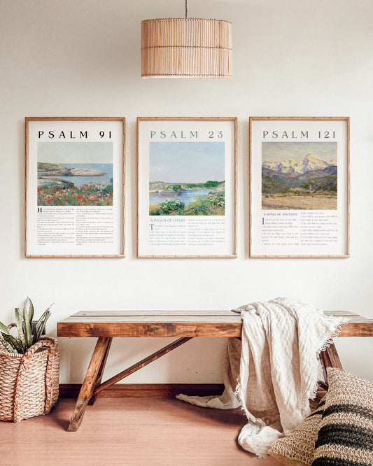Three framed prints titled 'Psalm 91', 'Psalm 23', and 'Psalm 121' above a wooden bench in a room.