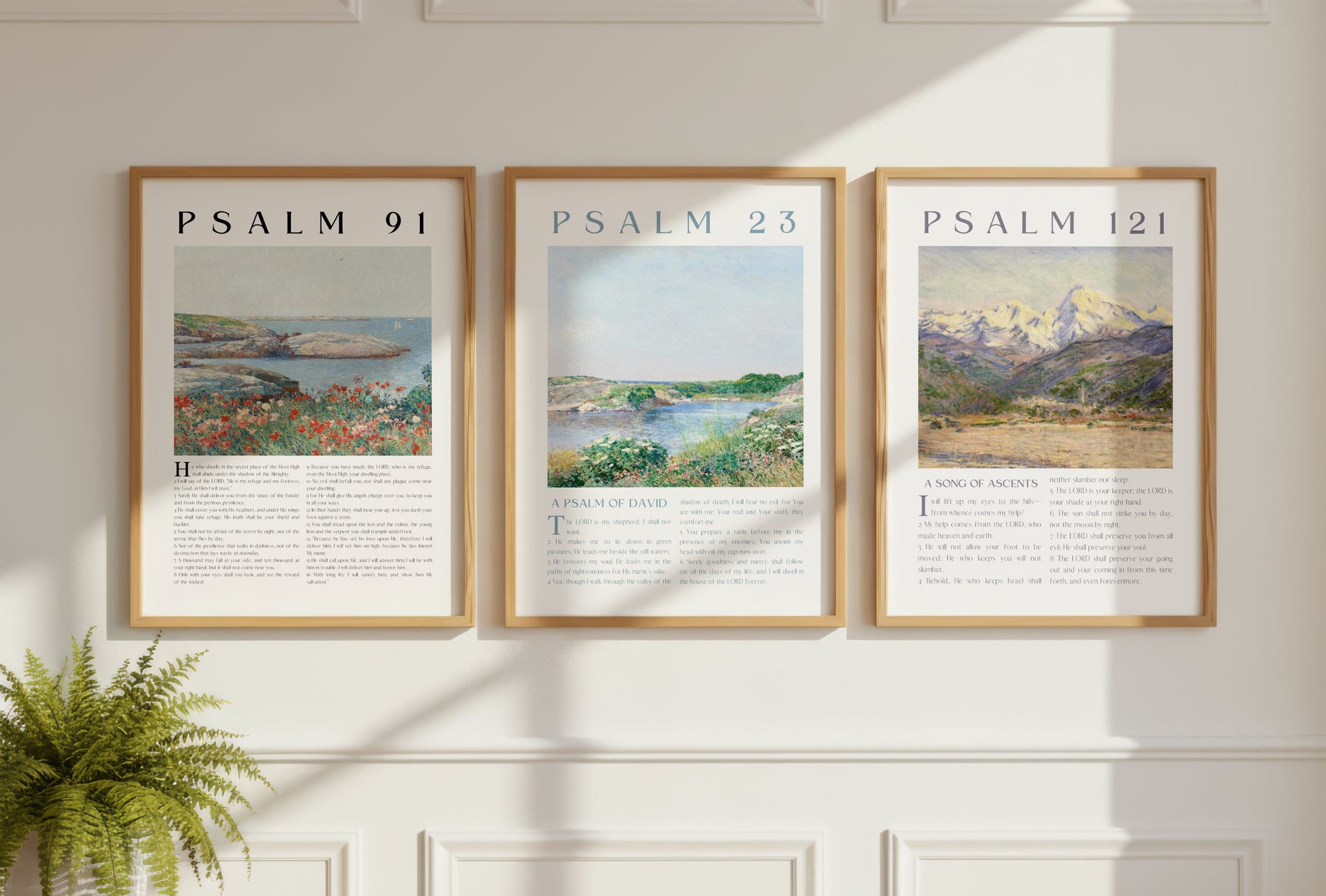 Three framed prints of Psalm 91, Psalm 23, and Psalm 121 on a wall with a plant on a table.