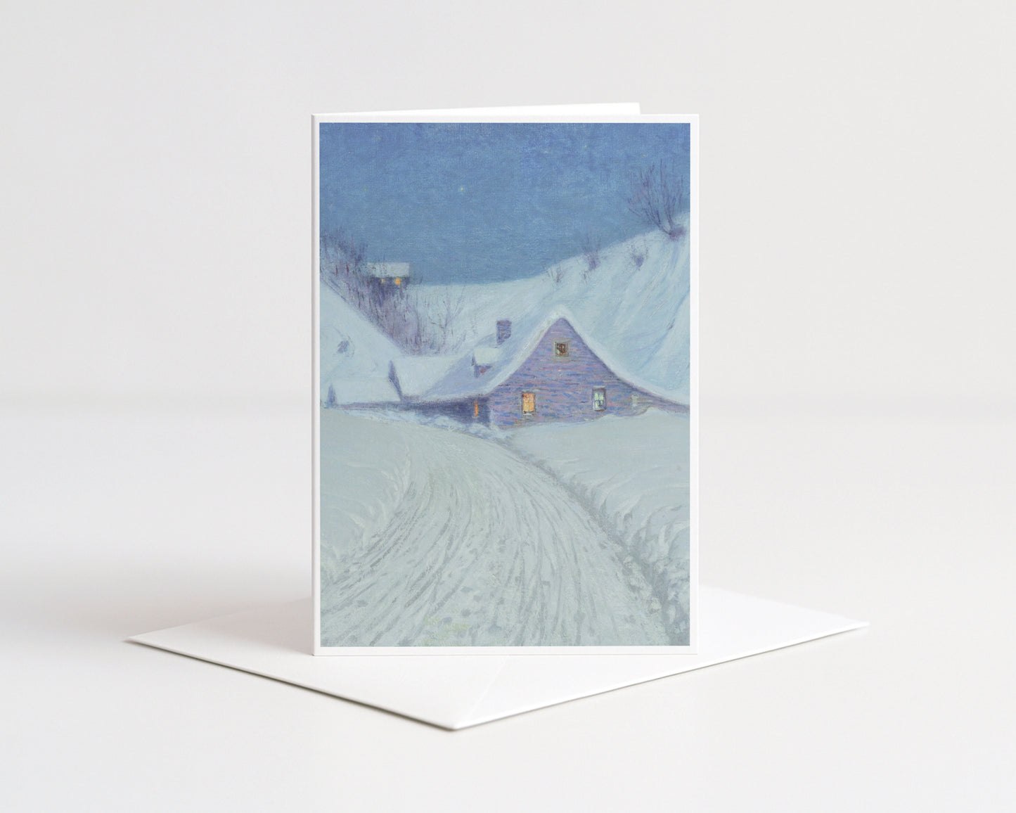 Greeting card with a snowy landscape and house on a white background