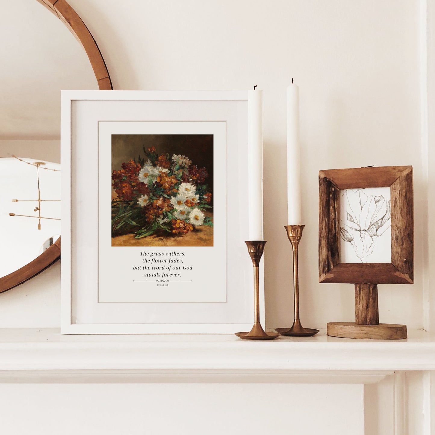 Decorative shelf with a mirror, framed artwork, candles, and wooden frames.